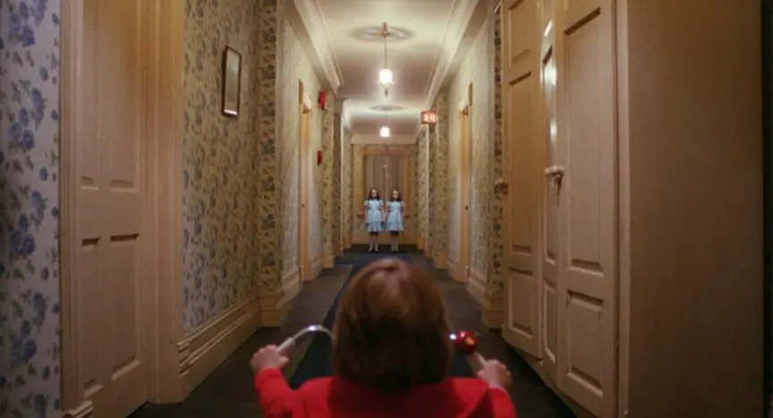 Danny and twin girls in hallway in Kubrick's The Shining